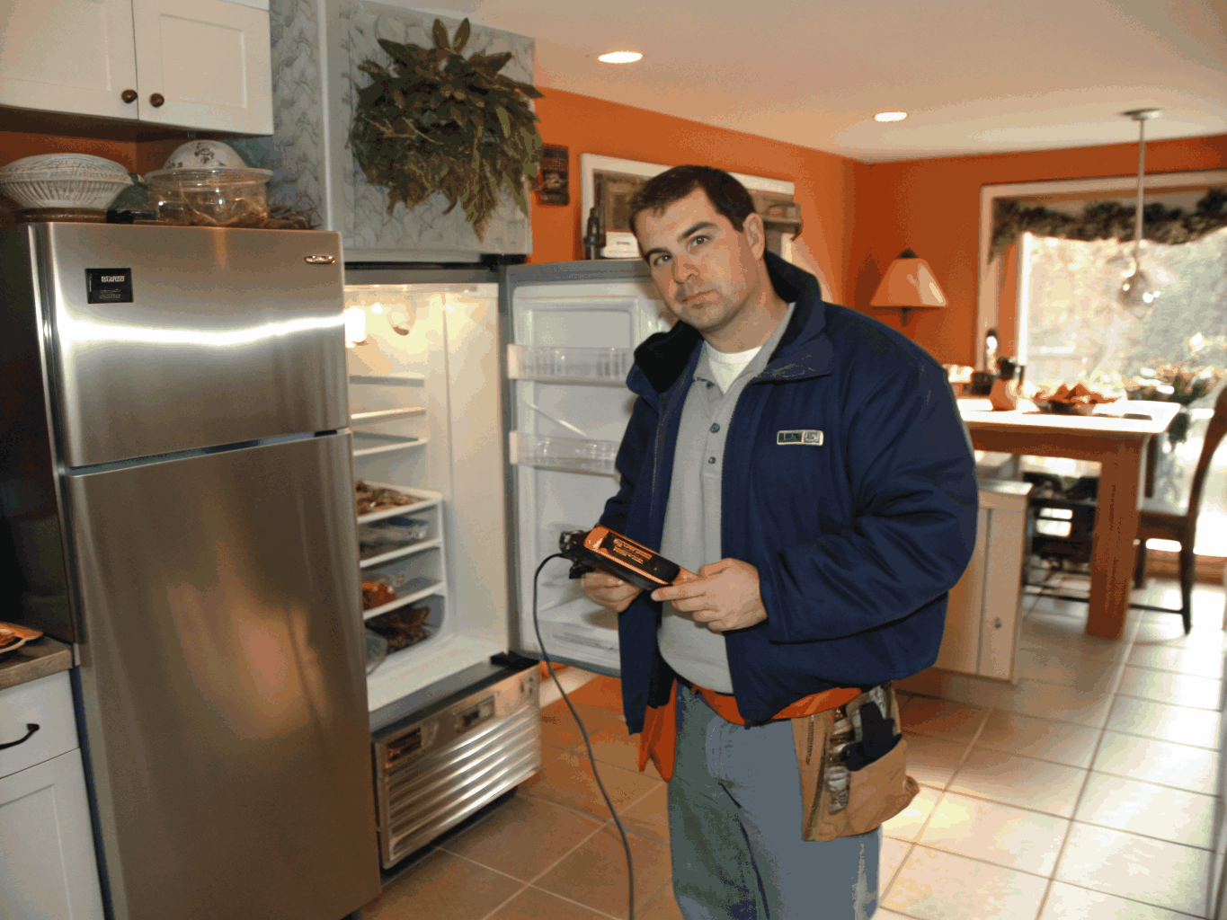 Appliance repair technician testing a kitchen stove cooktop in Johns Creek GA